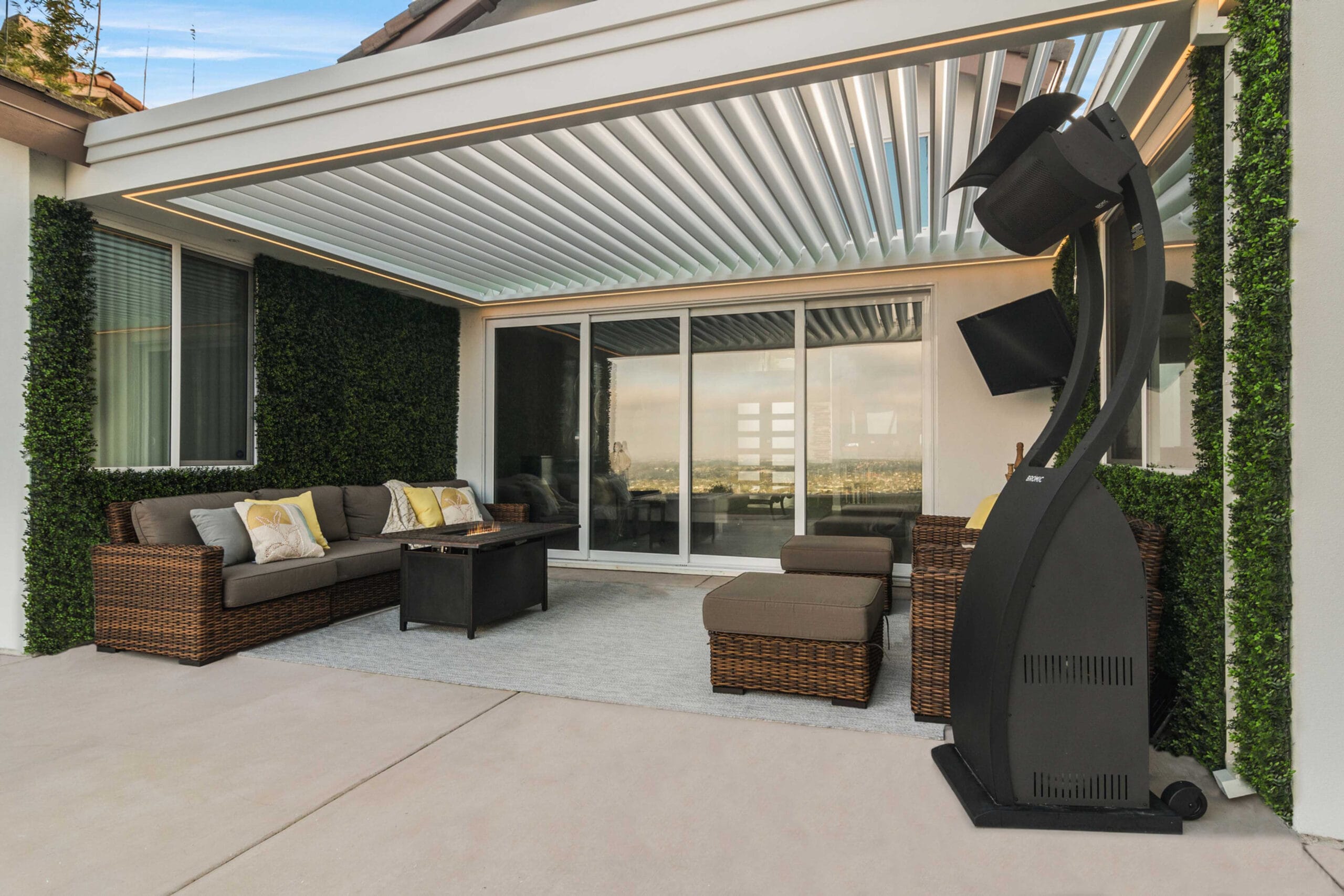 Weather-resistant louvered roof pergola with integrated lighting creating covered outdoor living space.