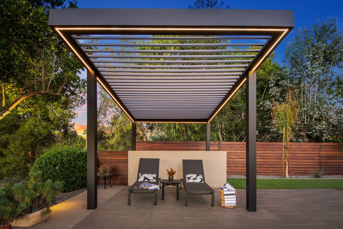 Smart louvered roof pergola with app-controlled louvers and built-in LED lighting covering backyard area.