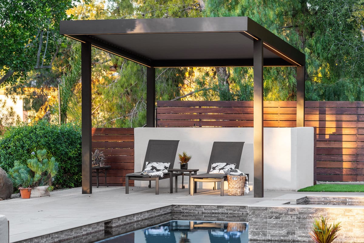 Aluminum louvered pergola with adjustable closed slats and integrated lighting by the pool