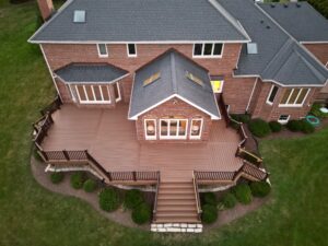 Custom Trex deck with stairs leading to a landscaped backyard, built by experienced Trex deck installers.