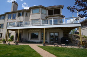 Composite deck balcony with glass in-fill railings perfectly blending with the Chicago suburban home's architecture.