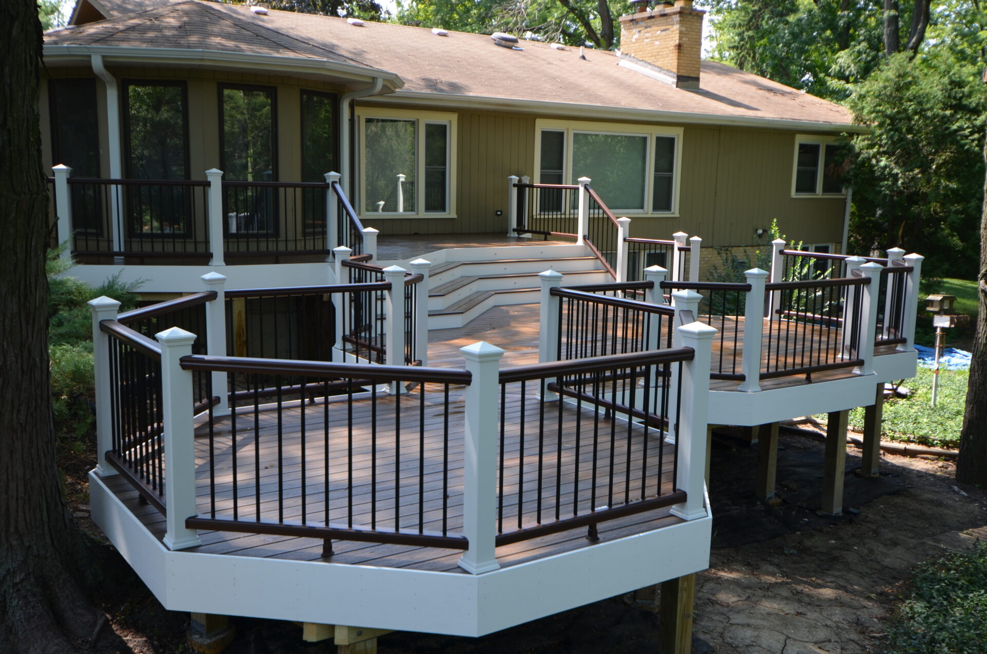 Multi-level custom curved Trex composite deck in the Chicago suburbs, IL, featuring elegant curves and tiered design blending with the house.