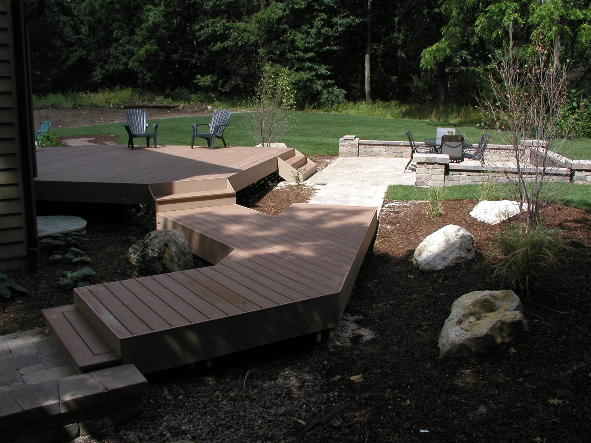 Composite deck to backyard patio transformation in Naperville, IL by Warner's Decking of Naperville.