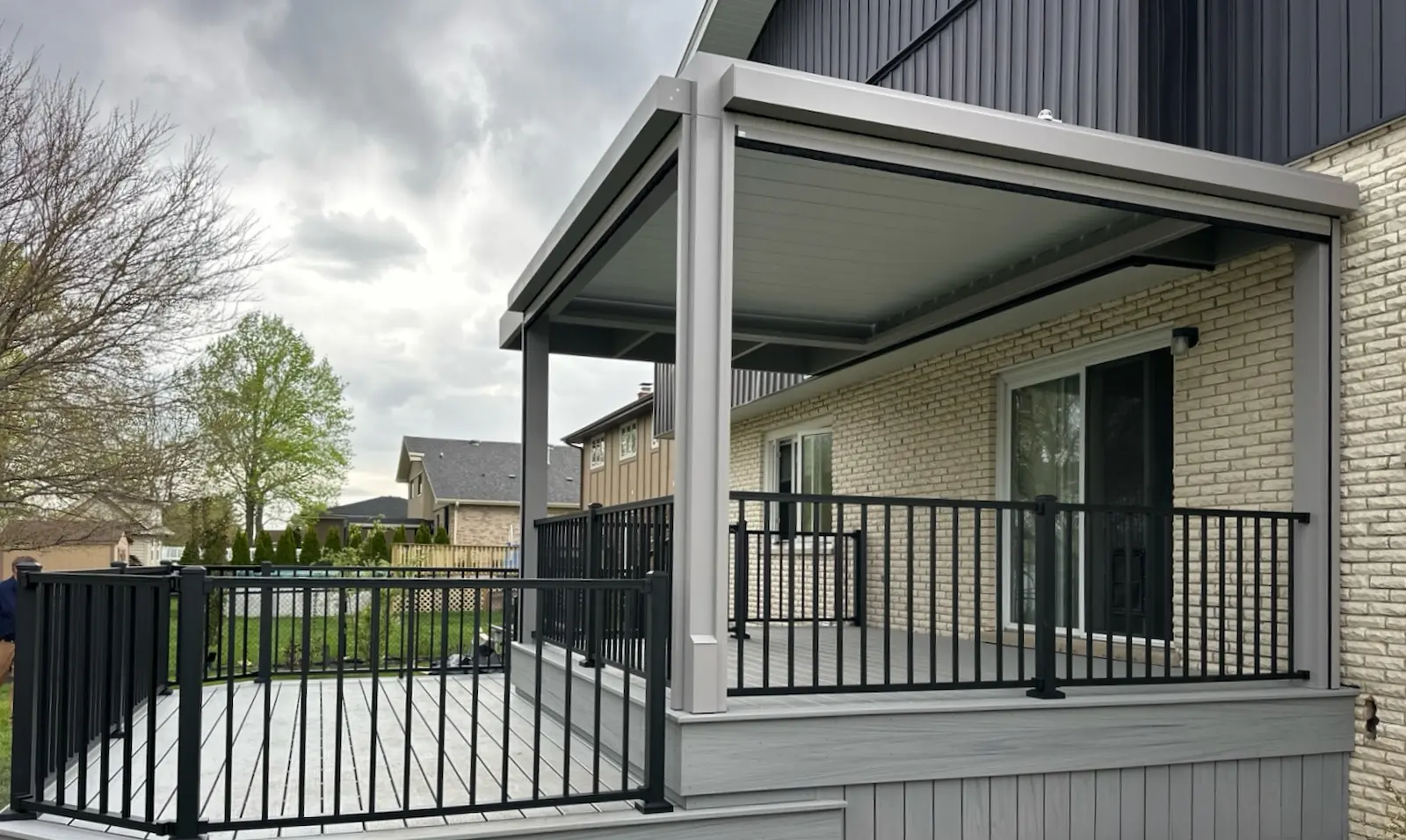 Trex deck with an attached louvered roof pergola.