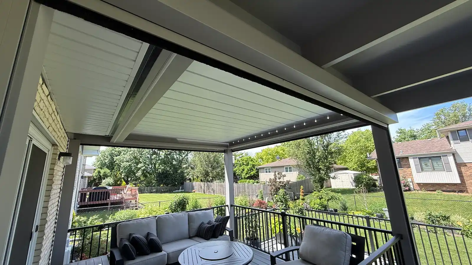 perspective view from under a closed louvered roof pergola on top of a trex deck highlighting unique features.