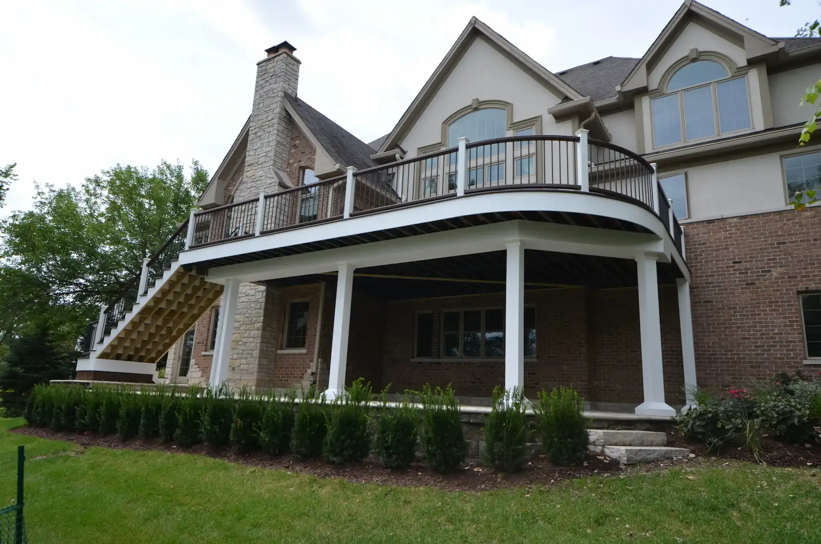 Raised curved composite deck blending with the home creating a luxury look.