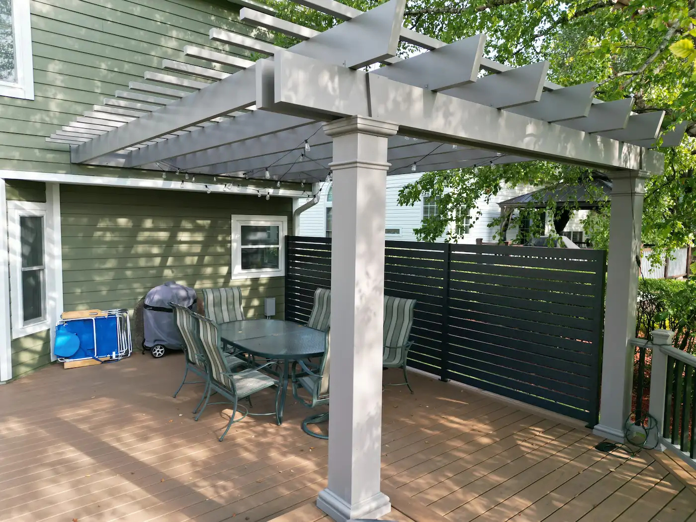 Attached fiberglass pergola and custom privacy fence wall built on a composite deck in the Chicago suburbs.