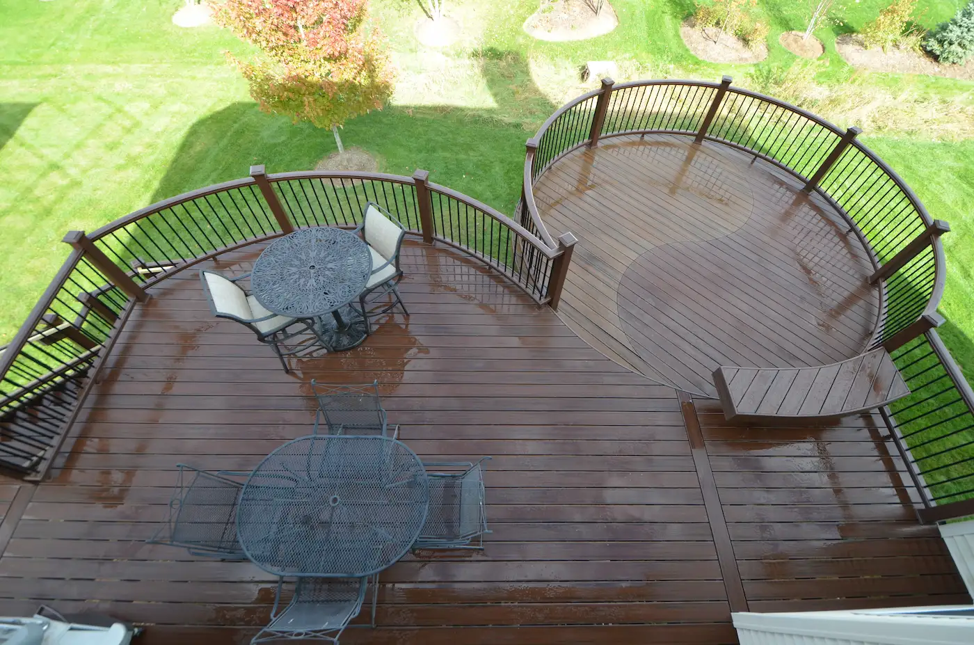 A custom-designed, curved Trex deck built on helical piers and steel deck framing.