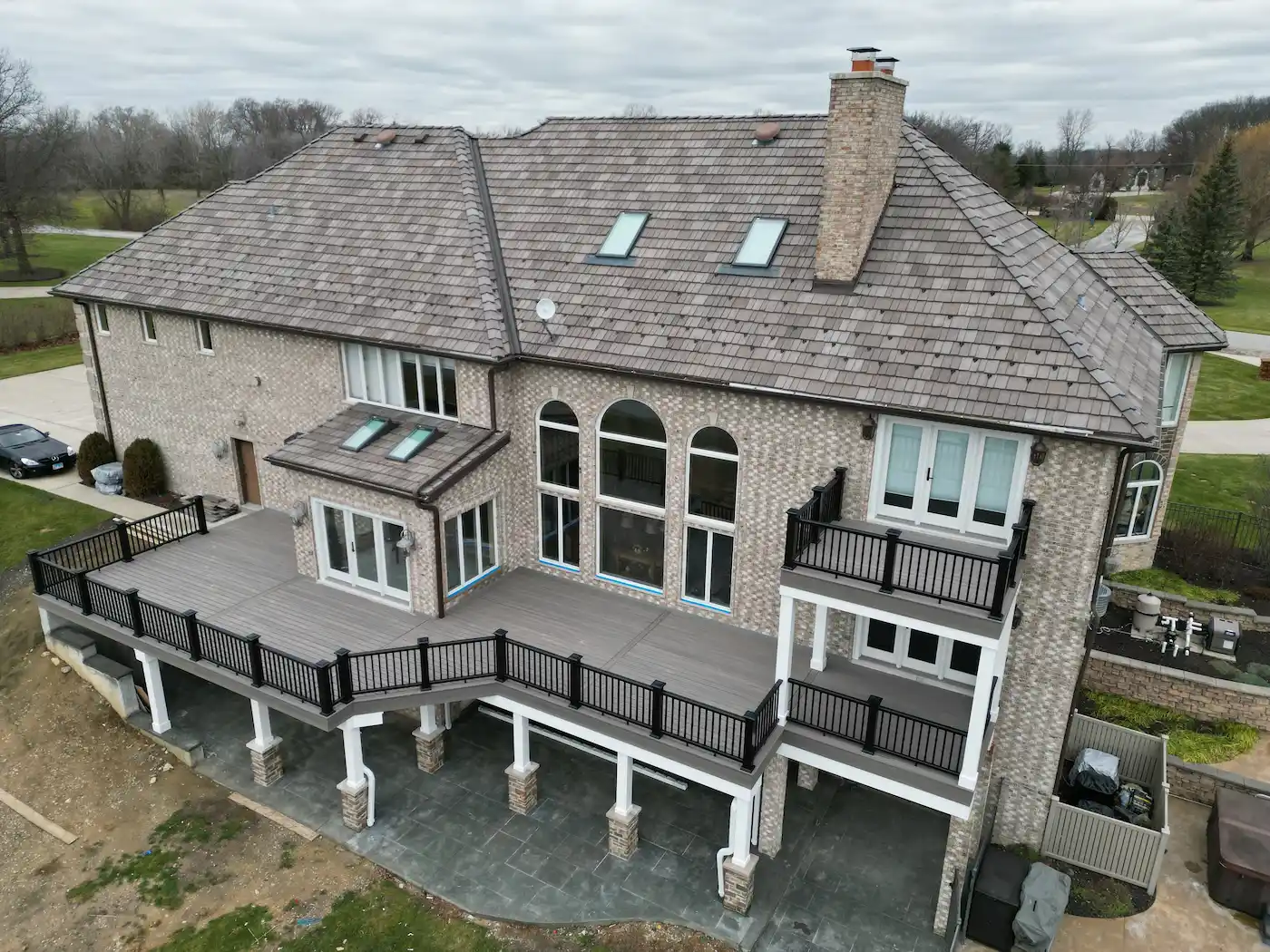A raised Trex composite deck with a RainEscape under-deck drainage system creating a finished dry space below, topped with a second-story balcony