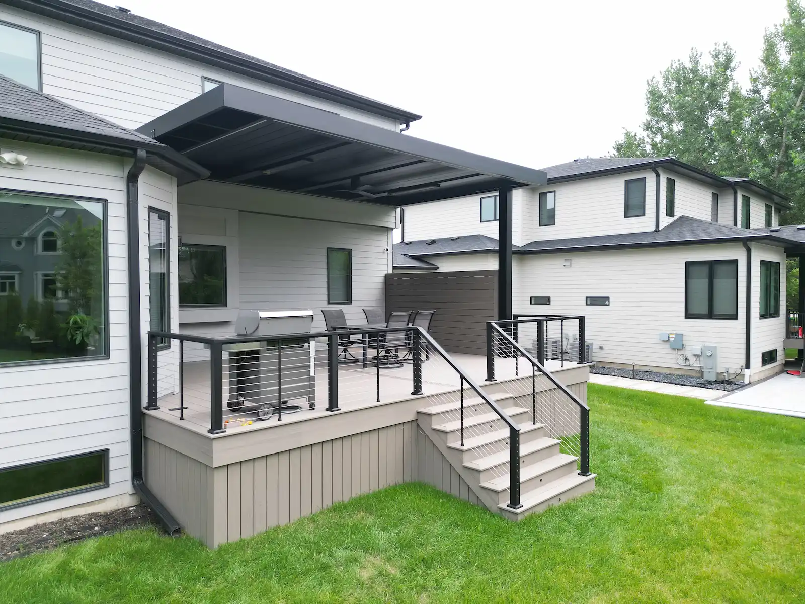 Trex Transcend Lineage composite deck with 5 stairs, privacy wall, and attached louvered pergola in Naperville, IL